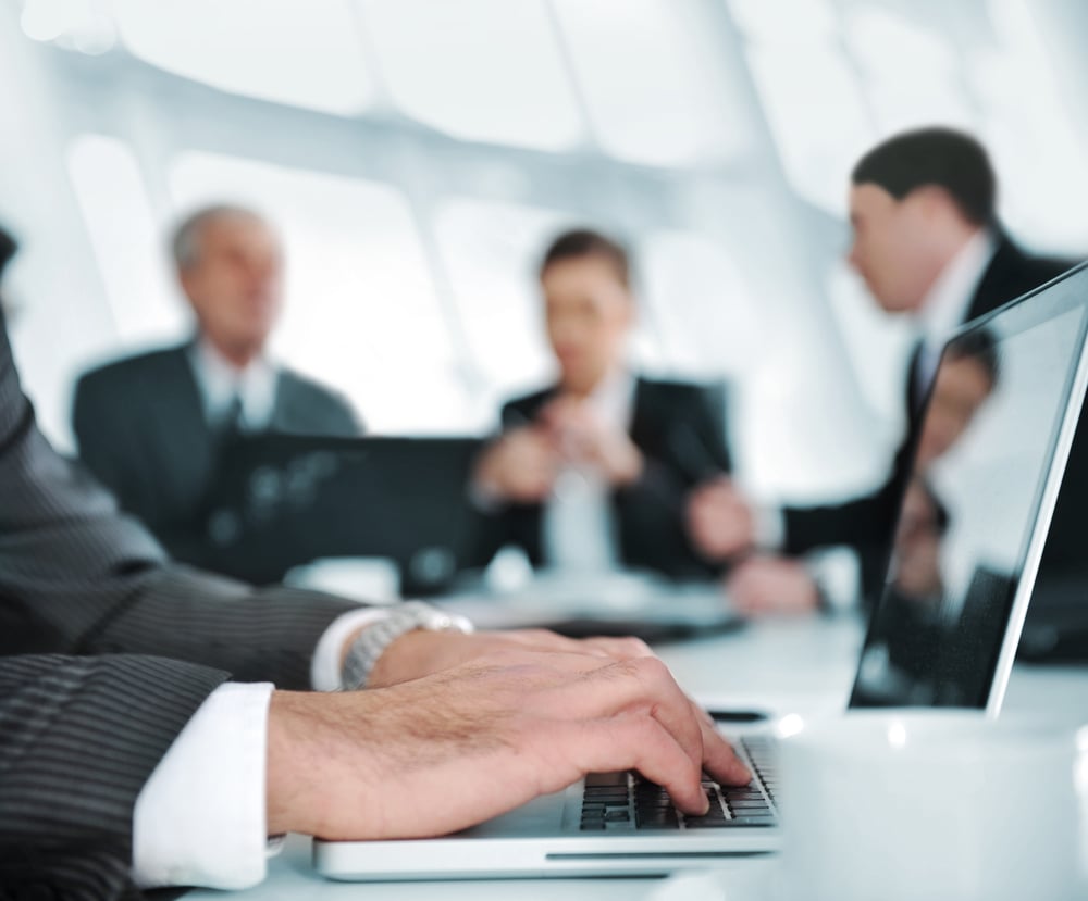 Typing on laptop while the business group having meeting Typing on laptop while the business group having meeting